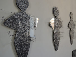 ANGELI,  2015 – INSTALLAZIONE A PARETE – FIGURE IN PIOMBO REALIZZATE A INCISIONE E BASSORILIEVO CON SOVRAPPOSIZIONE DI PLEXIGLASS (COME FRAMMENTI DI VETRO) E SCRITTURA – M 5,20